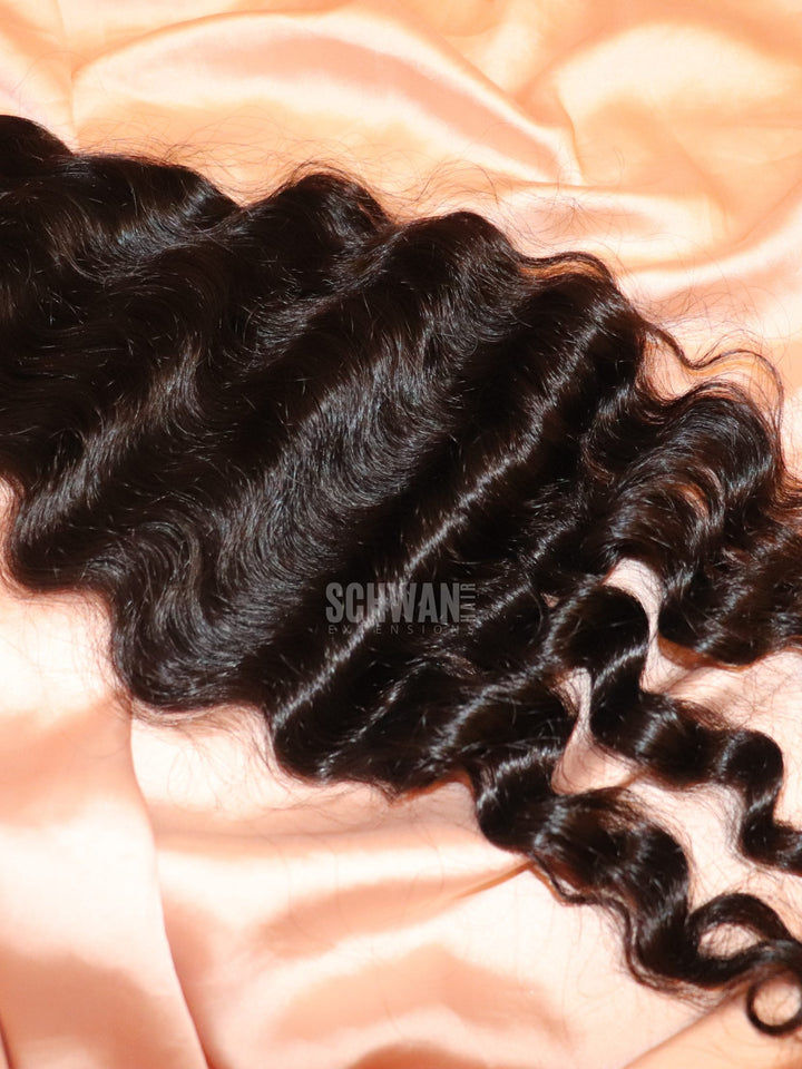 Bundle of Raw Natural Indian Curly Weft Hair extensions in peach background