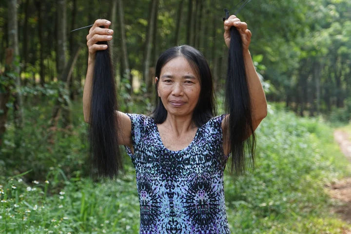 Hair donor holding up two lengths of her freshly cut single donor hair